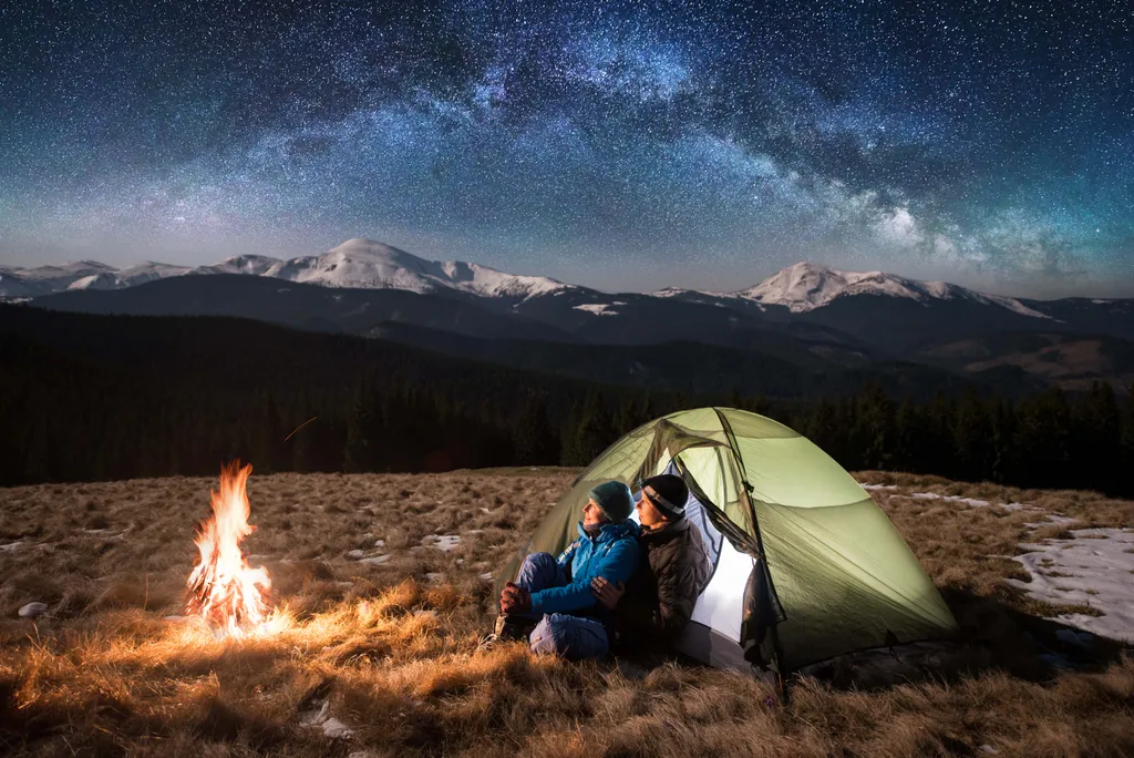 az emberek túrázás közben  Having camping,couple,happy,space,milky,trip,camper,campfire,sky,astrop Young couple tourists enjoying in the camping at night, having a rest near campfire and green tent under beautiful 