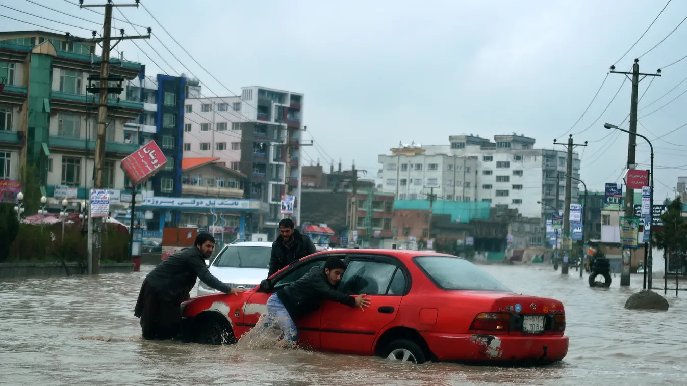 weather Horizontal Afghan volunteers push a stranded vehicle from floodwaters as heavy rain falls on a street in Kabul on April 2, 2016.  
Due to a poor or non-existent water management system, roads and lanes in the Afghan capital are often inundated wit
