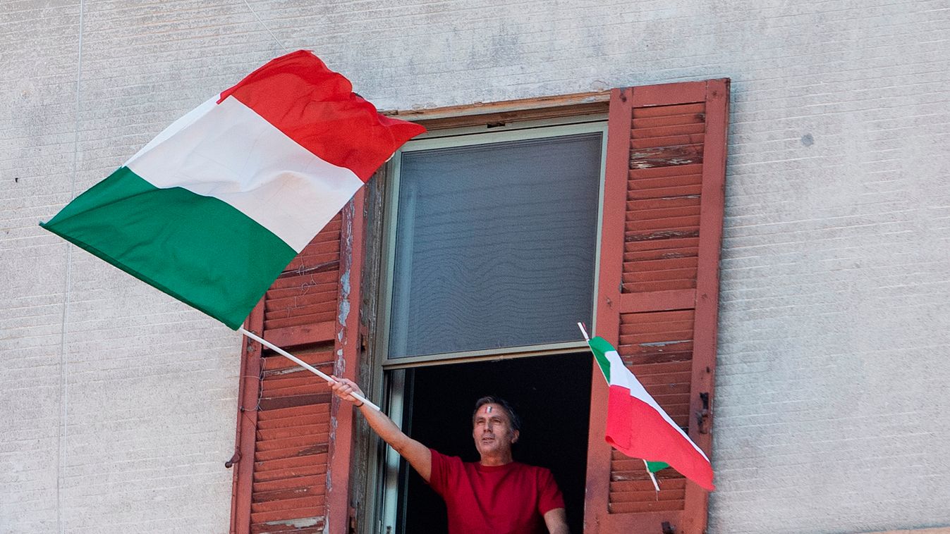 virus health Horizontal A resident waves the Italian flags in the Garbatella district of Rome on April 25, 2020 during a 'Liberation Day' flashmob with people singing Italian partizan song 'Bella Ciao' from their window or balcony, during the country's lo