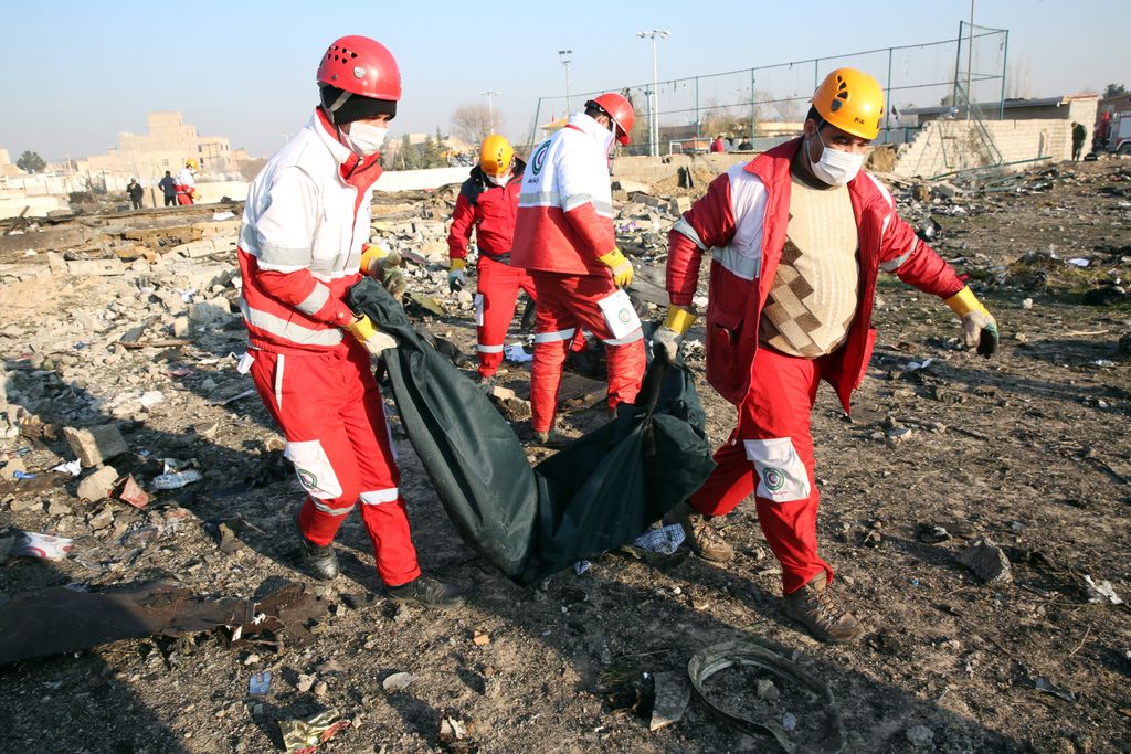 Sahriár, 2020. január 8.
Hullazsákot visznek a Vörös Félhold segélyszervezet munkatársai egy Boeing 737-es típusú ukrán utasszállító repülőgép roncsdarabjainál az iráni Sahriár város közelében 2020. január 8-án, miután a légi jármű hajnalban lezuhant 167 utassal és 9 fős személyzettel a fedélzetén, kevéssel a teheráni Khomeini Imám repülőtérről történt felszállás után. A szerencsétlenséget senki sem élte túl.
MTI/EPA/Abedin Taherkenareh 