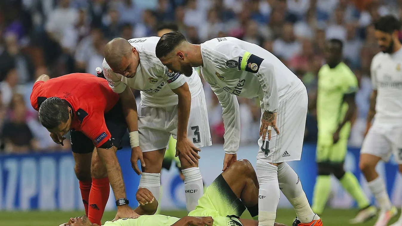Pepe (k) és Sergio Ramos (j), a spanyol Real Madrid játékosai megnézik Vincent Kompanyt, az angol Manchester City sérült csapatkapitányát a labdarúgó Bajnokok Ligája elődöntőjének visszavágó mérkőzésén a madridi Santiago Bernabeu Stadionban 