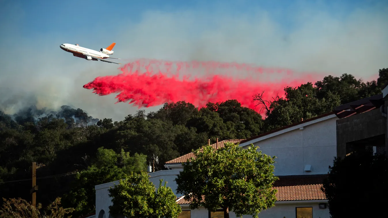 Newhall, 2019. október 12.
Repülőgépről ledobott tűzgátló anyaggal próbálják megfékezni a lángokat a kaliforniai Newhallban 2019. október 11-én. A Kalifornia déli részén pusztító lángok eddig házak tucatjait semmisítette meg, tízezreknek kellett elhagynia