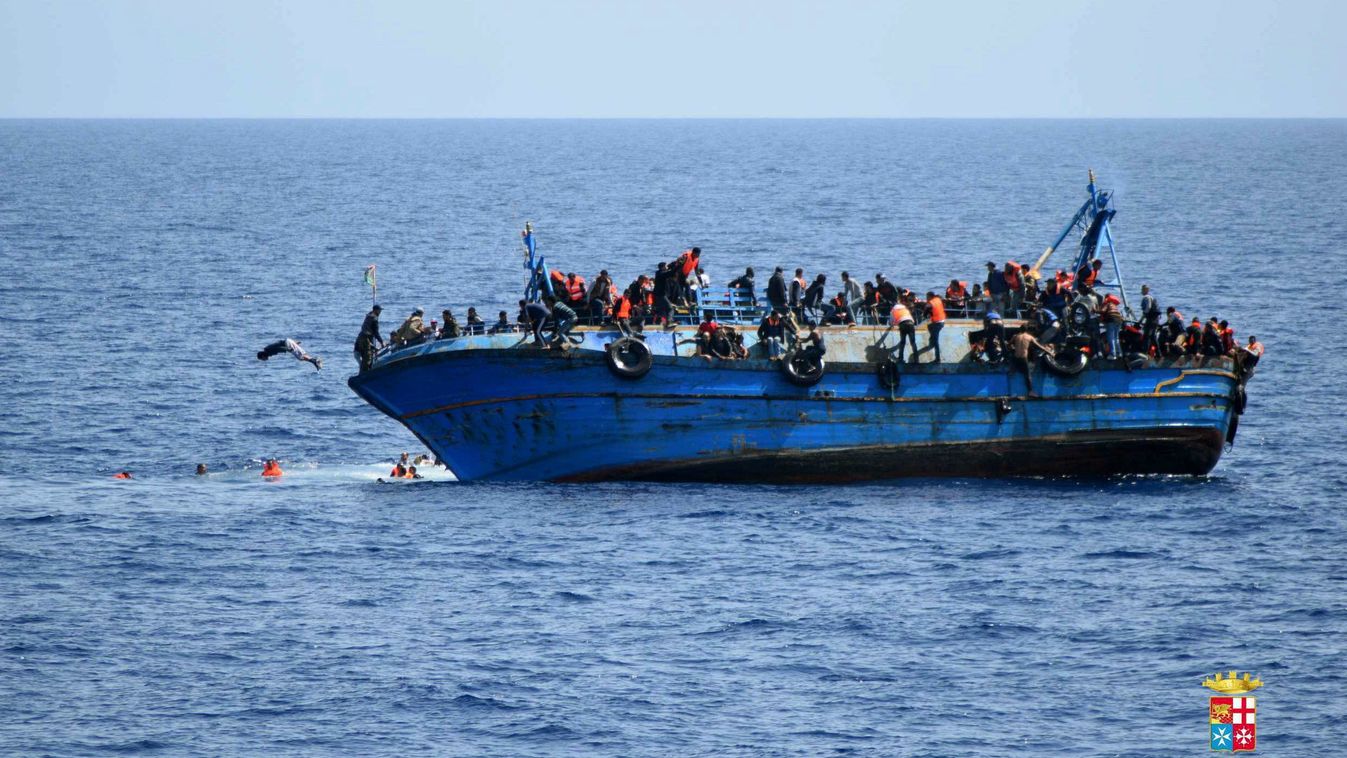Líbia, 2016. május 25.
Az olasz haditengerészet által közreadott felvételen migránsok ugrálnak a tengerbe egy megbillent hajó fedélzetéről Líbia partjainál 2016. május 25-én. Az elmúlt egy napban a mentést irányító olasz haditengerészet egyéb hajók közrem