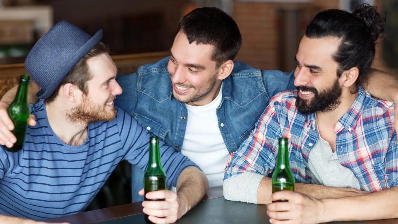 happy male friends drinking beer at bar or pub Pub Social Gathering Leisure Activity Beer Bottle Men Males Group Of People Bachelor Young Adult Smiling Talking Sitting Drinking Embracing Holding Customer Fun Southern European Descent Latin American and Hi