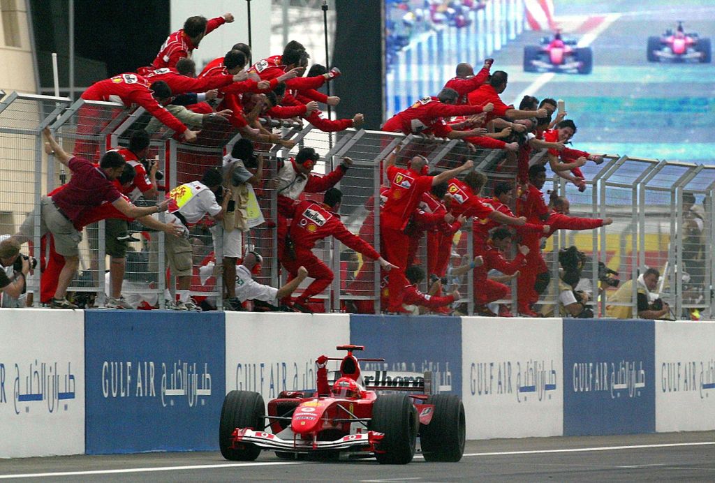 Formula 1 - Michael Schumacher wins in Bahrain BAHRAIN:BHR Motor_Racing SPO Sports action cheering ferrari_team FLAG formula_1 formula_one happy race_car race_course single HORIZONTAL 