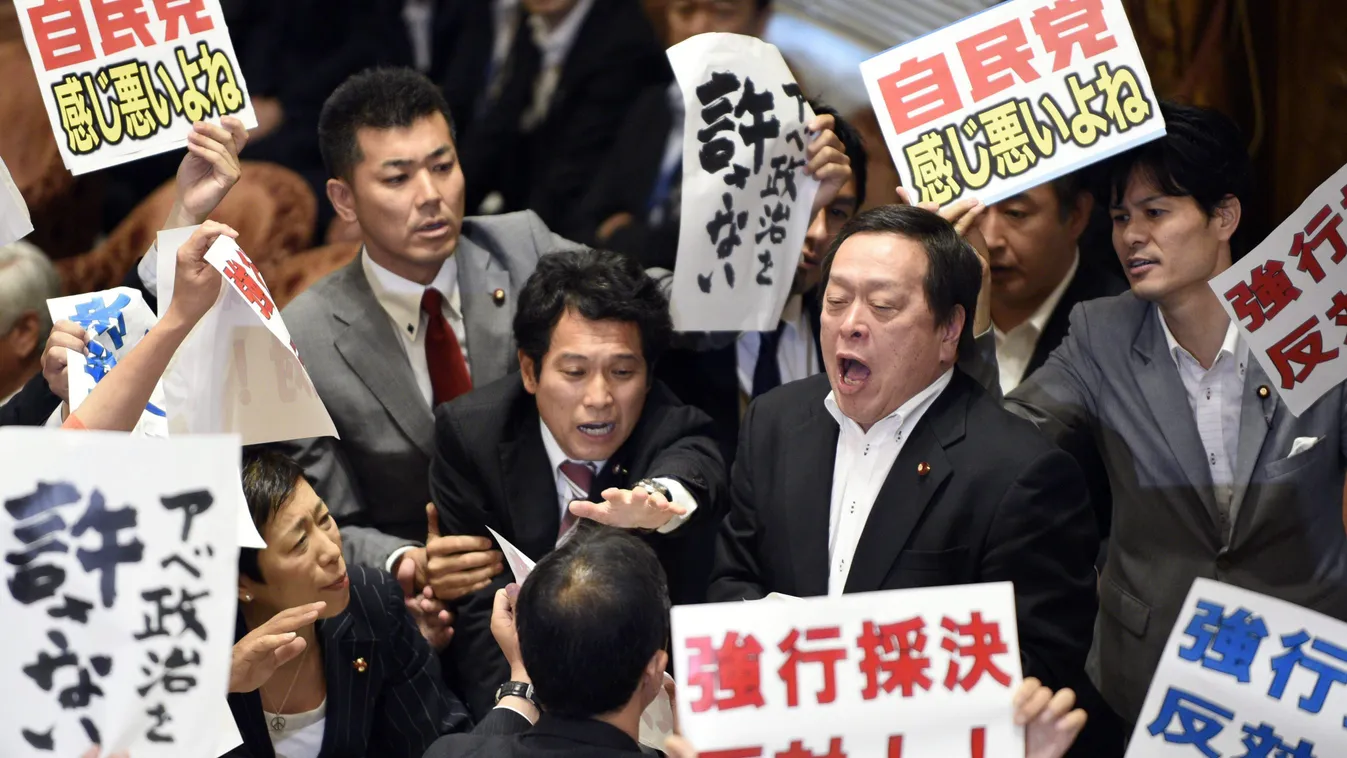 Tokió, 2015. július 15.
Ellenzéki politikusok, köztük Hamada Jaszukadzu (k, jobbról) "Ellenezzük az erőszakos törvényeket!" és "Abe politikája megbocsáthatatlan!" feliratú transzparensekkel tüntetnek a tokiói parlamentben 2015. július 15-én, miután az als