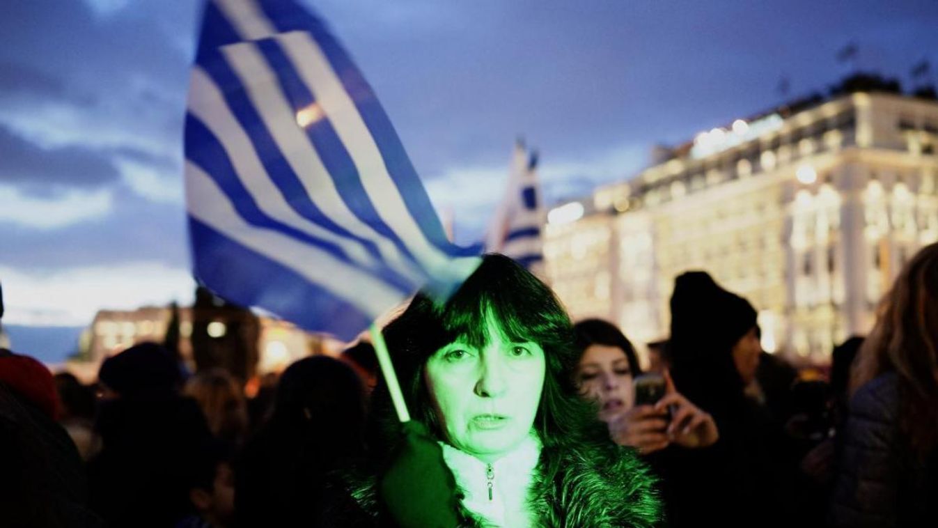 Egy görög zászlót tartó nő a kormányzati megszorításokat ellenző tüntetésen (2015. február 11.) 