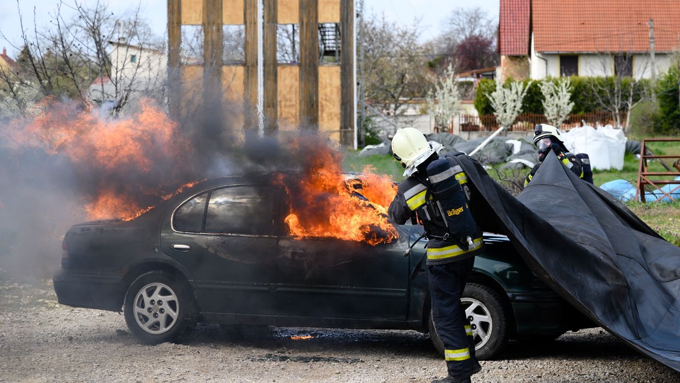 autó Foglalkozás KÖZLEKEDÉSI ESZKÖZ lángol lángoló autó SZEMÉLY tűzoltó tűzoltó takaró tűzoltó takaró bemutató, 	Elektromos járművek hatékony tűzoltását segítő eszközt adtak át 