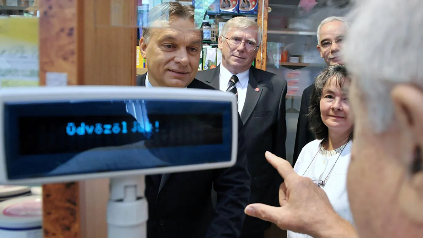 gyógyszertárak államosítása, patika, Orbán Viktor miniszterelnök (b) egy vásárlóval beszélget a Róna Patikában