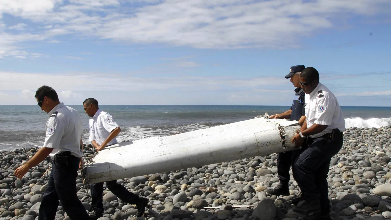 Saint-André, 2015. július 30.
Egy repülőgép roncsdarabját viszik rendőrök az Indiai-óceánban elterülő, Franciaországhoz tartozó Réunion szigetén fekvő Saint-Andréban 2015. július 29-én. Egy szakértő szerint a roncsdarab egy Boeing 777-es típusú gépé, de g