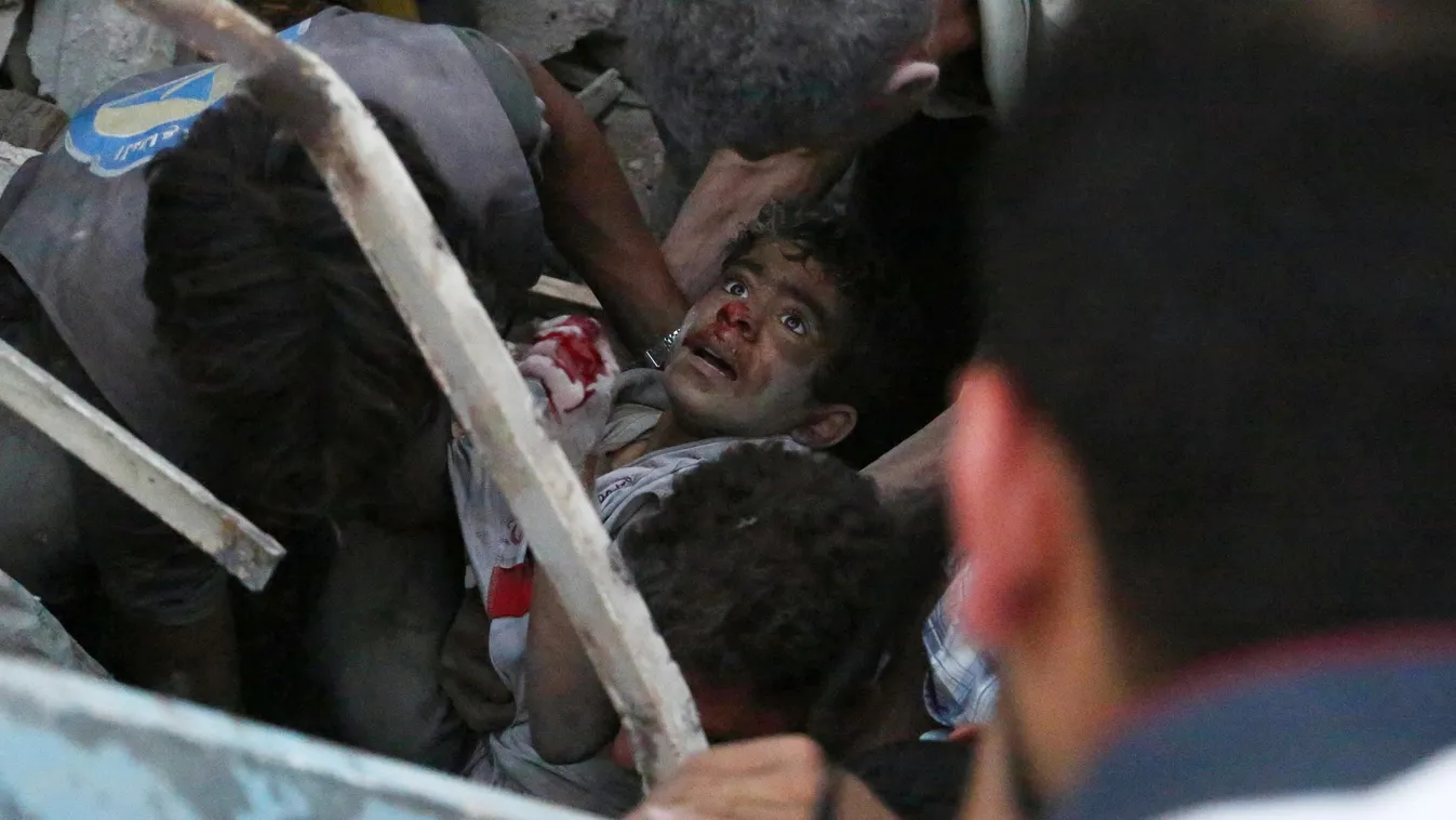 MIDDLE EAST CHILD IN WAR CIVIL WAR REVOLT VICTIM CASUALTY CIVILIAN POPULATION CONSQUENCES OF WAR RESCUE EMERGENCY SERVICES RUINS HORIZONTAL SURVIVOR Syrians evacuate an injured boy from rubble following a reported air strike on a rebel-held town of Douma,
