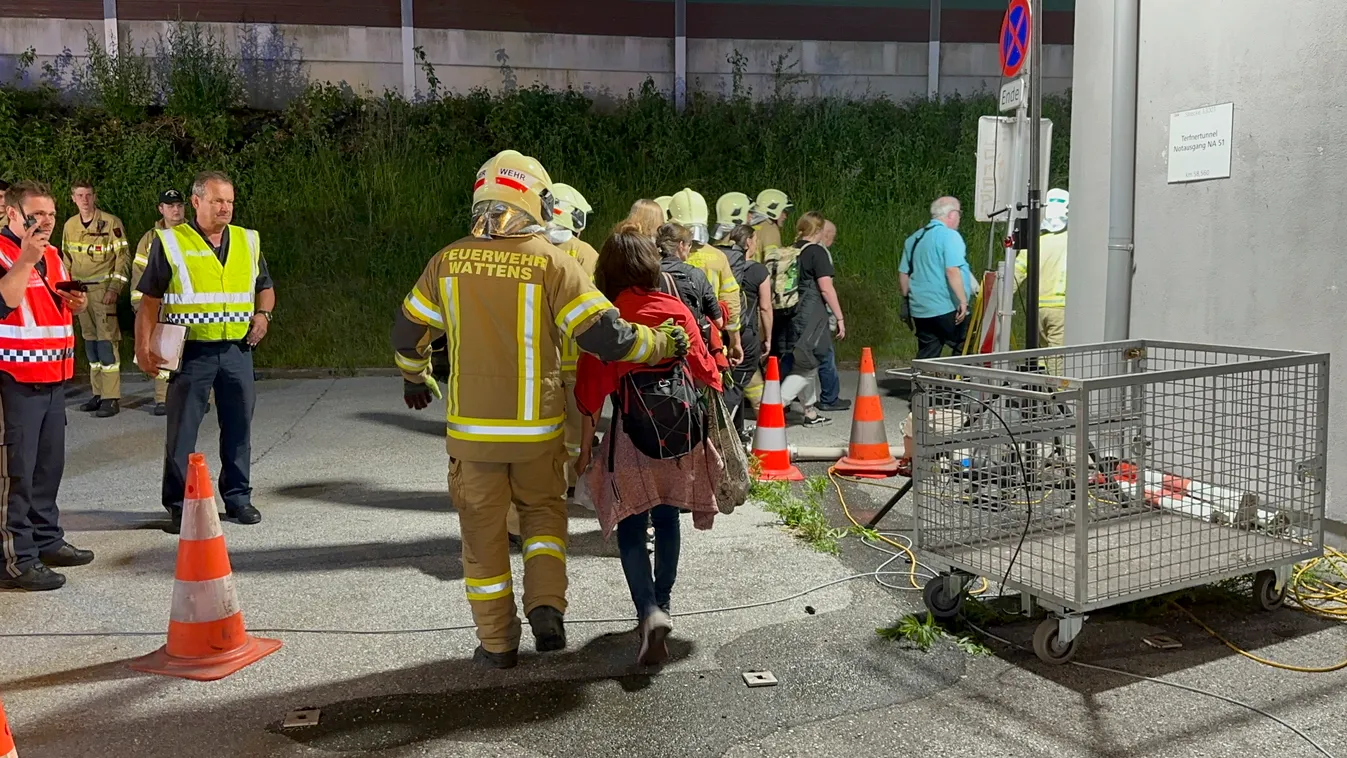 Fritzens, 2023. június 8.
Tűzoltók kísérik ki az utasokat egy vasúti alagútból a tiroli Fritzens településnél, Innsbruck közelében 2023. június 7-én este, miután műszaki hiba miatt kigyulladt egy Innsbruckból Amszterdamba tartó személyvonat az alagútban. 