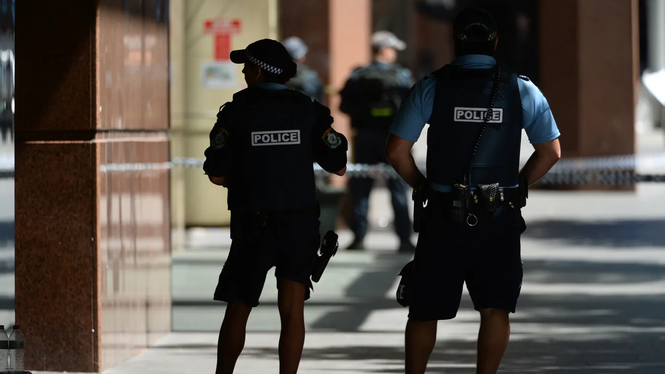 Armed police are seen near a cafe in the central business district of Sydney on December 15, 2014. A gunman was holding terrified hostages inside a Sydney cafe December 15 with an Islamic flag displayed at the window, triggering a lockdown in an area home