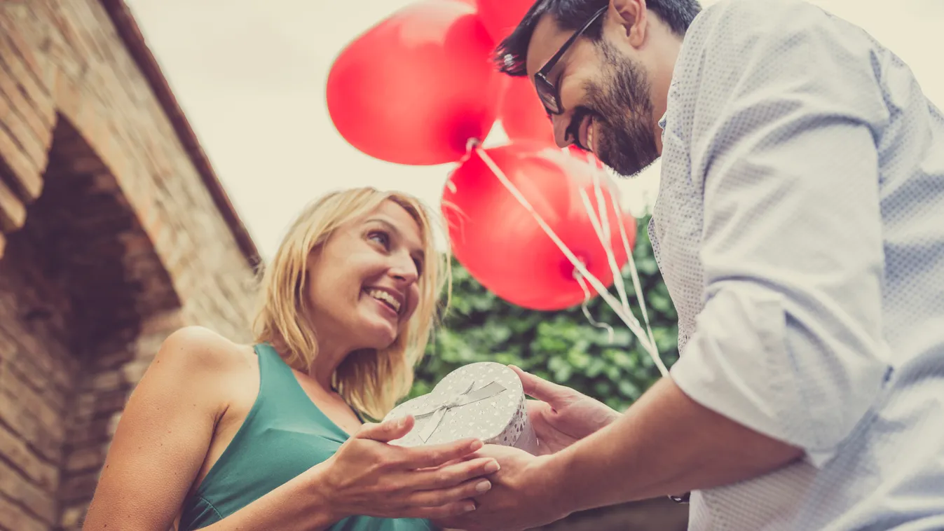 Woman receives a gift from her man Couple Women Females Men Males Dating Flirting Valentine's Day - Holiday Giving Caucasian Ethnicity Togetherness Enjoyment Romance Love Outdoors Affectionate Loving Human Hand People Gift Balloon Birthday Casual Clothing