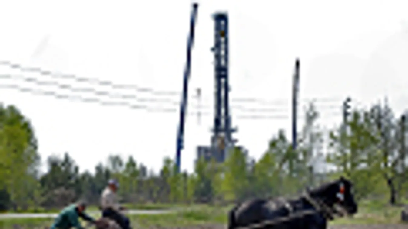 Lengyel földművesek a háttérben egy palagázt kitermelő fúrótorony, Grzebowlik