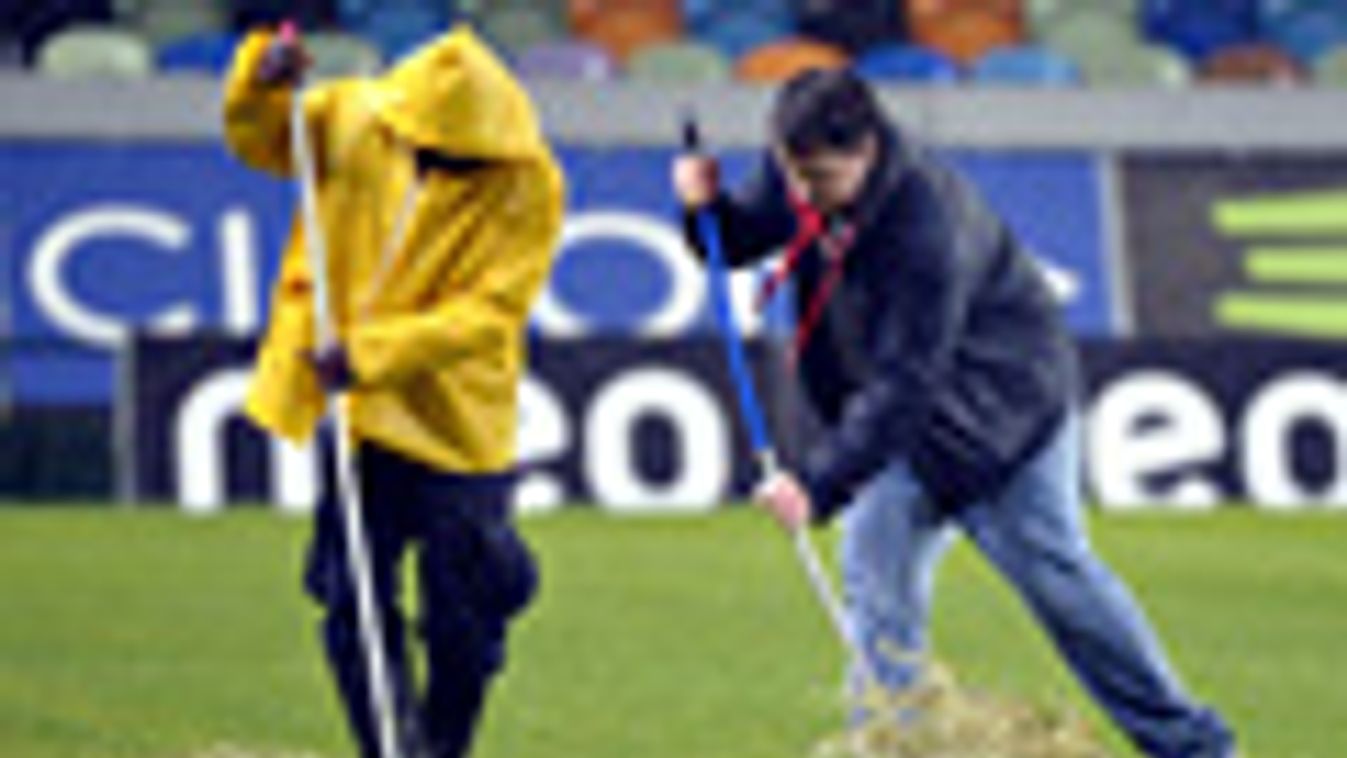 Munkások takarítják a vizet a Jose Alvalade stadionban, ahol felhőszakadás miatt késik a Sporting Lisboa - Videoton mérkőzés
