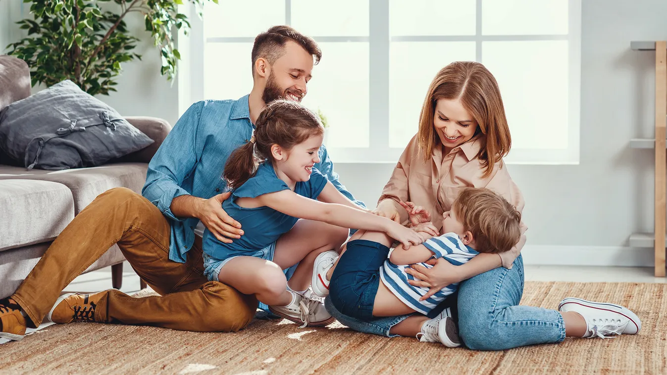 Happy,Father,And,Mother,With,Little,Children,Sitting,On,Floor offspring,parent,communicate,dad,happy,mom,merry,relation,mother Happy father and mother with little children sitting on floor near sofa and laughing while having fun together at home during we