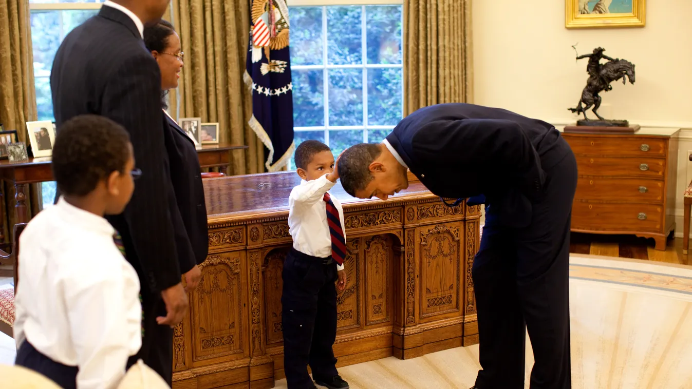 President Barack Obama President Barack Obama bends over so the son of a White House staff member can pat his head during a visit to the Oval Office May 8, 2009.  Official White House Photo by Pete Souza.  This official White House photograph is being mad