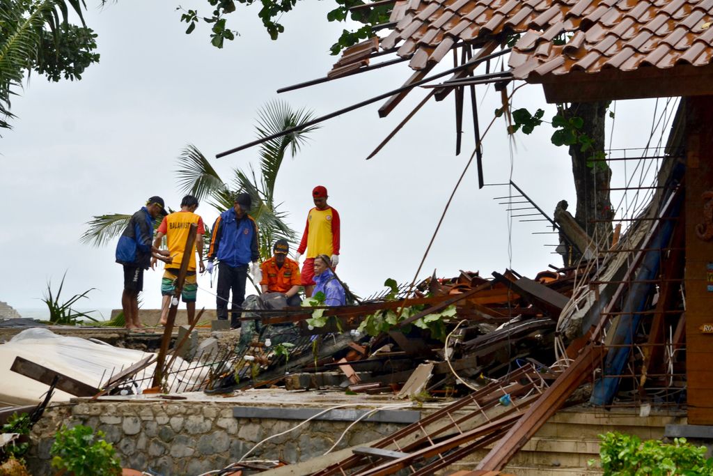 Horizontal Officials look through the wreckage of damaged buildings in Carita on December 23, 2018, after the area was hit by a tsunami on December 22 following an eruption of the Anak Krakatoa volcano. - A tsunami following a volcanic eruption killed 62 