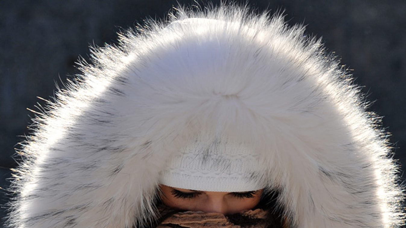 időjárás, tél, hó, fagy, fiatal lány prémes kabátba és sálba burkolja magát a -20 fokos hidegben Kijevben, Ukrajna 