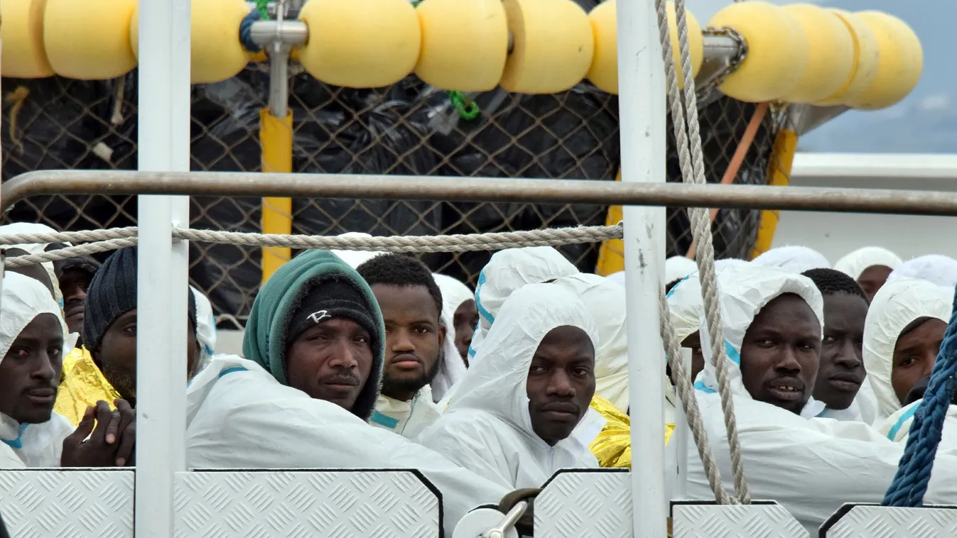 TOPSHOTS Horizontal IMMIGRATION IMMIGRANT ASYLUM SEEKER REFUGEE RESCUE police technique et scientifique Men wait to disembark from the Italian Coast Guard vessel "Dattilo" following a rescue operation of migrants and refugees at sea, on February 1, 2016 i