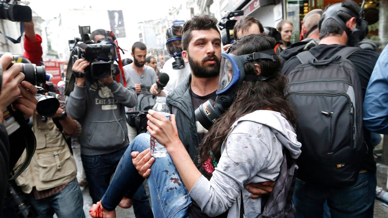 Isztambul, 2014. május 31.
Sebesült, gázmaszkot viselő nőt visz egy férfi az isztambuli Taksim téren rendezett tüntetésen 2014. május 31-én. 