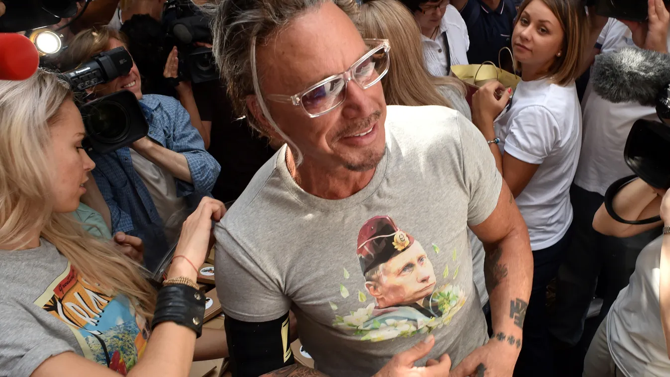 US actor Mickey Rourke (C) stands in front of journalists as he wears a T-shirt with the portrait of Russia's President Vladimir Putin in central Moscow on August 11, 2014. The sale of a new collection of T-shirts with Putin's portrait starts in the Russi