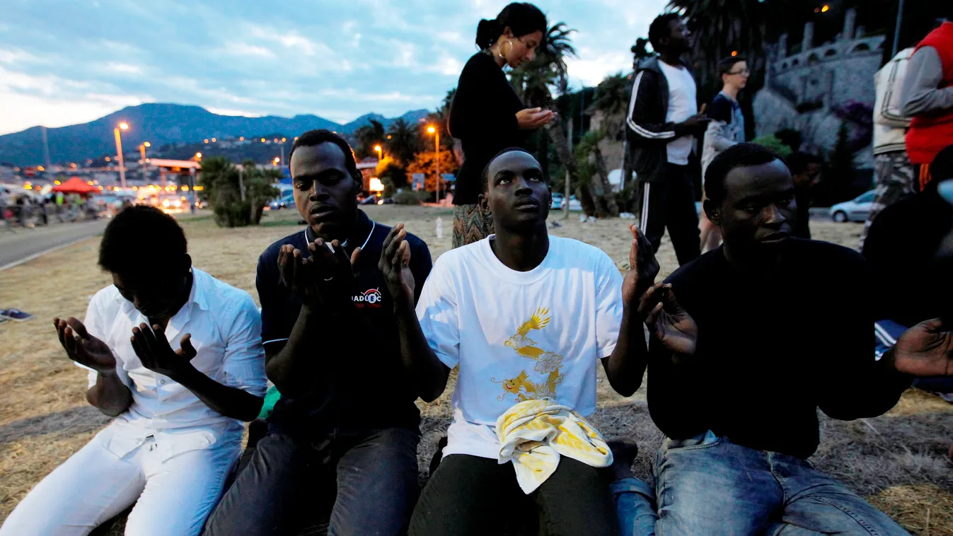 HORIZONTAL BORDER IMMIGRATION IMMIGRANT ILLEGAL IMMIGRANT ASYLUM SEEKER BEACH PRAYER RAMADAN RELIGION ISLAMIC RELIGION Migrants pray on June 17, 2015, on the eve of the holy fasting month of Ramadan, in the city of Ventimiglia, in Italy, near the French b