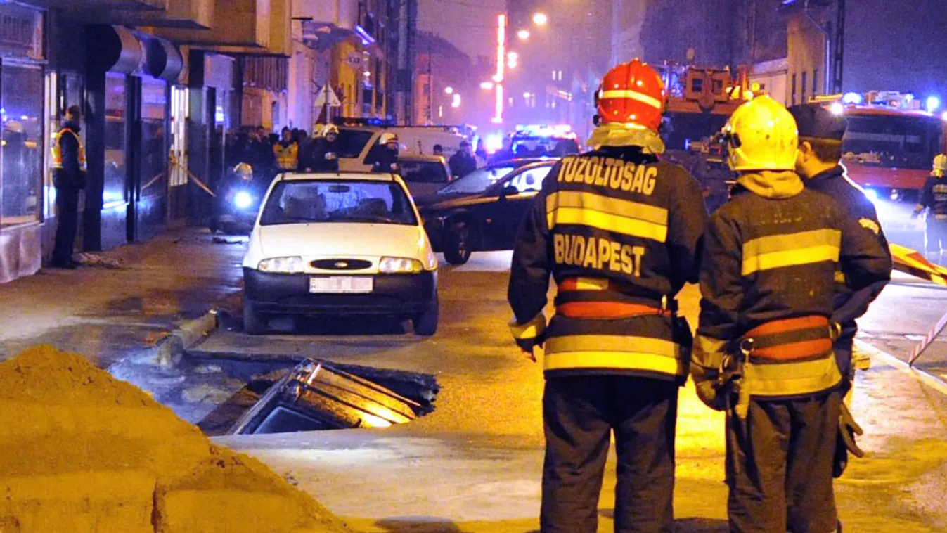 Tűzoltók és rendőrök Budapesten, a VIII. kerületi Karácsony Sándor utcában, ahol egy vélhetően csőtörés miatt keletkezett gödörbe esett egy személygépkocsi 2013. november 18-án.
