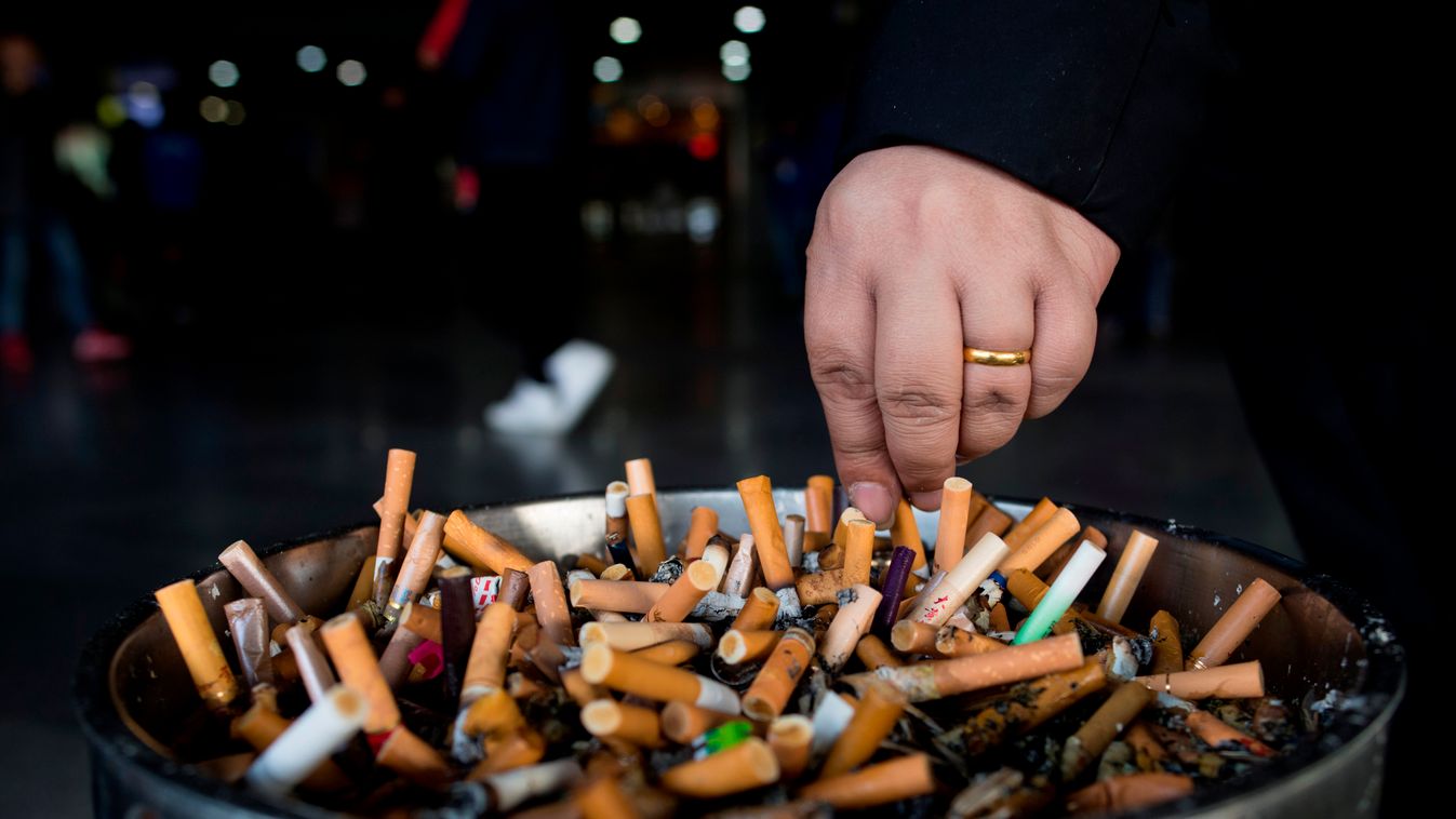 health tobacco Horizontal In this photo taken on February 28, 2017, a man grinds out his cigarette in an ashtray at a railway station in Shanghai.  
Shanghai widened its ban on public smoking March 1 as China's biggest city steps up efforts to stub out th