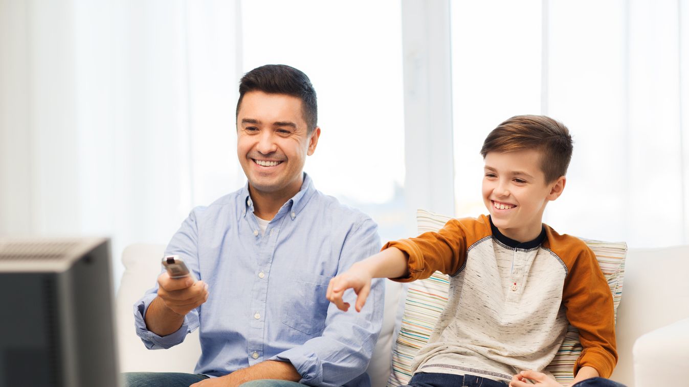 smiling father and son watching tv at home Leisure Activity Boys Men Males Remote Control Mature Adult Young Adult Child Smiling Pointing Sitting Watching Showing Movie Spectator Fun Southern European Descent Latin American and Hispanic Ethnicity Change C