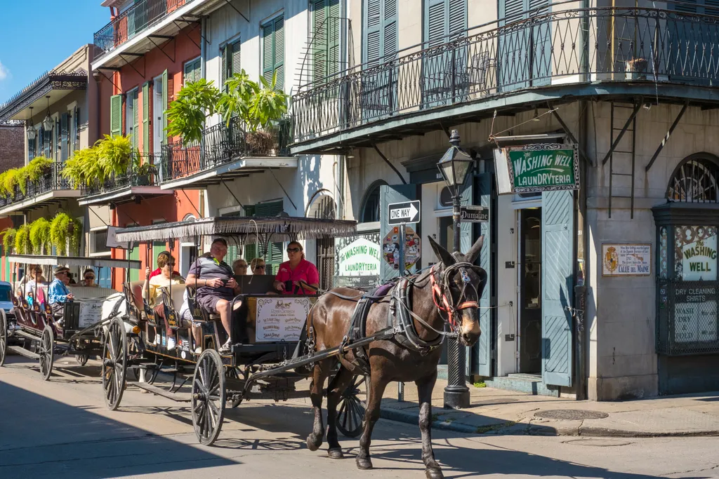 United States, Louisiana, New Orleans, French Quarter. Horse-drawn carriage and buildings on Bourbon St. travel destination Photography HORIZONTAL Colour Image French Quarter New Orleans Louisiana United States of America NORTH AMERICA Bourbon Street Hors