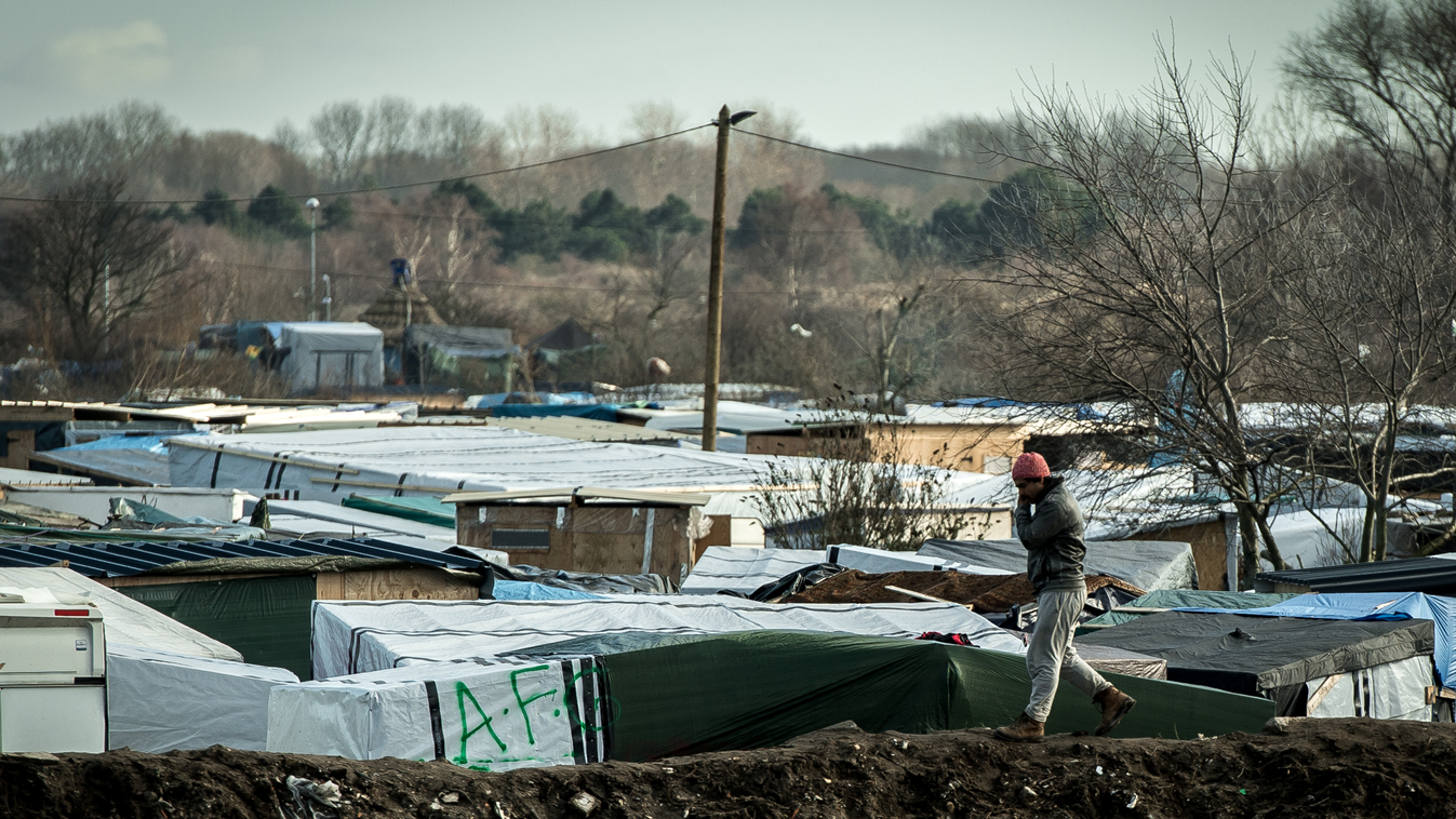 TOPSHOTS Horizontal IMMIGRATION MIGRATION AND IMMIGRATION WASTE GROUND CAMP MAKESHIFT SHELTER TENT REFUGEE IMMIGRANT DYKE A migrant walks on a embankment of earth surrounding the "jungle" migrants and refugee camp on February 19, 2016 in Calais, northern 