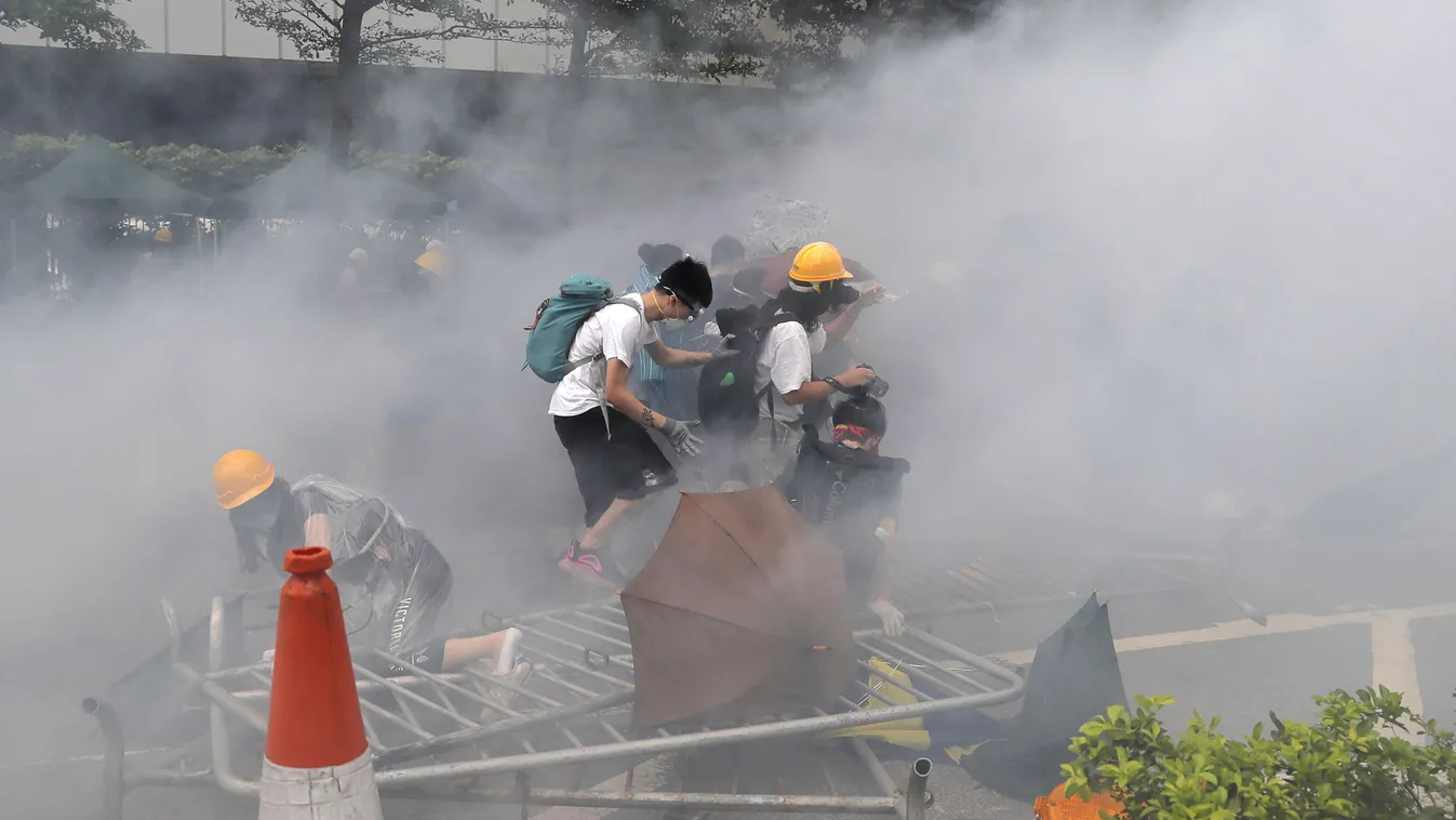 Hongkong, 2019. június 12.
Tüntetők rendőrségi könnygáz felhőjében a kiadatási egyezmény ellen tartott tiltakozáson a törvényhozó testület épülete előtt Hongkongban 2019. június 12-én. A törvényjavaslat lehetővé tenné, hogy Hongkong kiadjon szökevényeket 