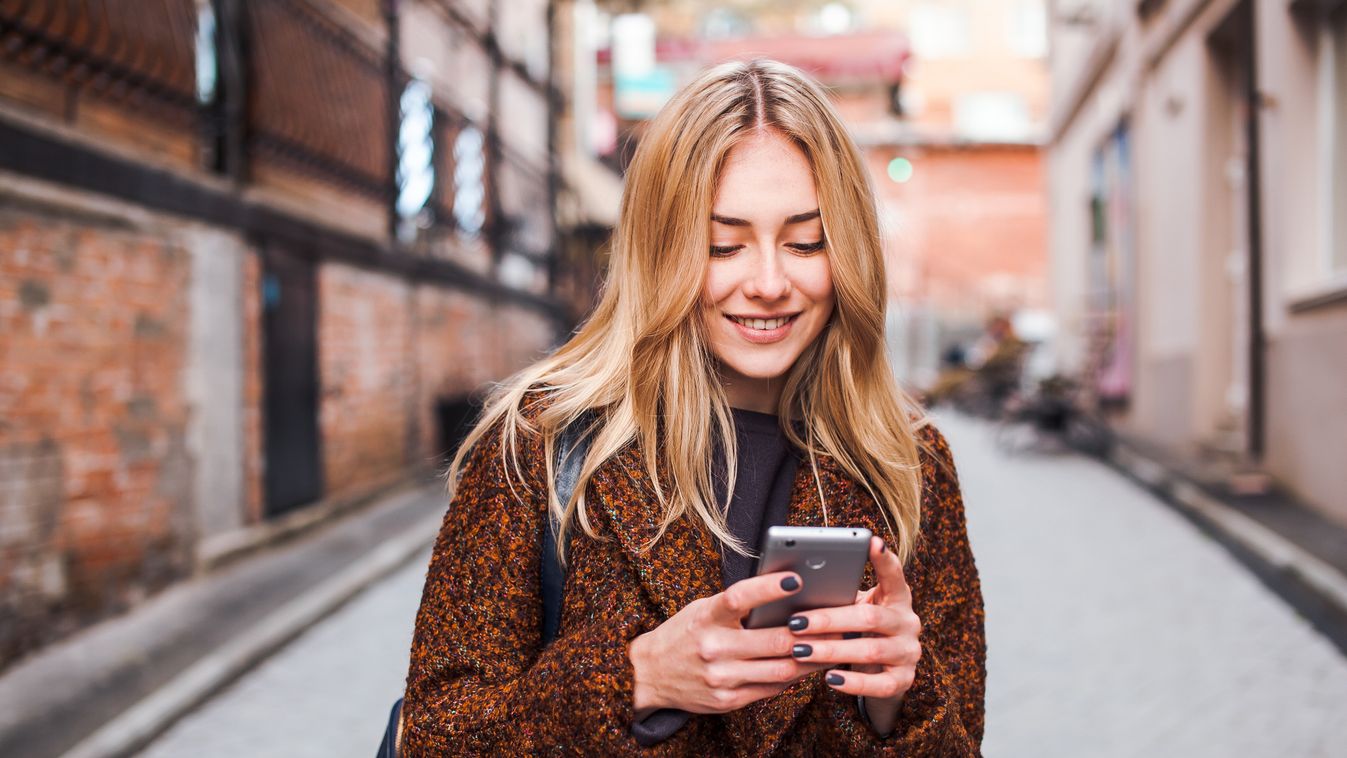 Young,Beautiful,Blonde,And,Dreamy,Woman,Wearing,Casual,Terracotta,Coat smartphone,woman,city,student,young,happy,cell,smart,smile,beaut Young beautiful blonde and dreamy woman wearing casual terracotta coat writes sms online with smartphone chatting at st