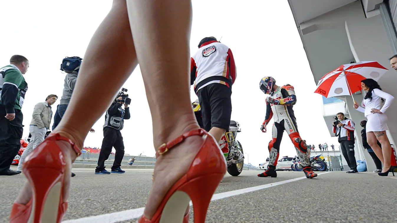 nap sportképe, Grid girlök veszik körül a német Stefan Bradl motorost a MotoGP Német Nagydíjának első szabadedzésén, 2013. július 12-én