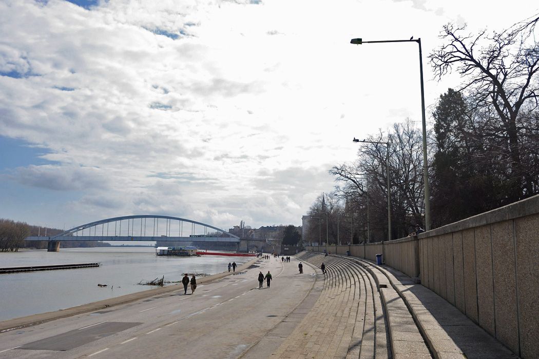 Járókelők sétálnak Szegeden a tavaszi napsütésben a Tisza áradása miatt a járműforgalom elől lezárt rakparton. A városban a hőmérséklet délután elérte a 17 Celsius-fokot