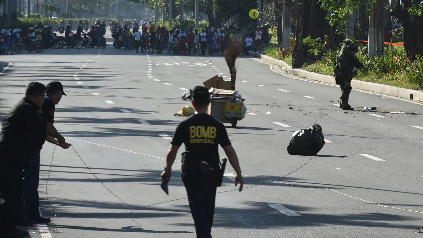 Horizontal A member of police bomb disposal unit (R) holding a water bomb disruptor, walks towards the site where a suspicious package was found, for detonation along Roxas boulevard near the US embassy in Manila on November 28, 2016.
According to press r