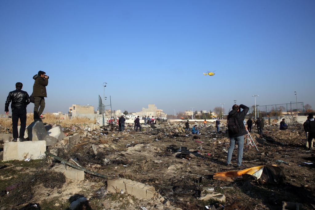 Mentőegységek és a sajtó munkatársai dolgoznak egy Boeing 737-es típusú ukrán utasszállító repülőgép roncsdarabjainál az iráni Sahriár város közelében 2020. január 8-án, miután a légi jármű hajnalban lezuhant 167 utassal és 9 fős személyzettel a fedélzetén, kevéssel a teheráni Khomeini Imám repülőtérről történt felszállás után. A szerencsétlenséget senki sem élte túl. 
