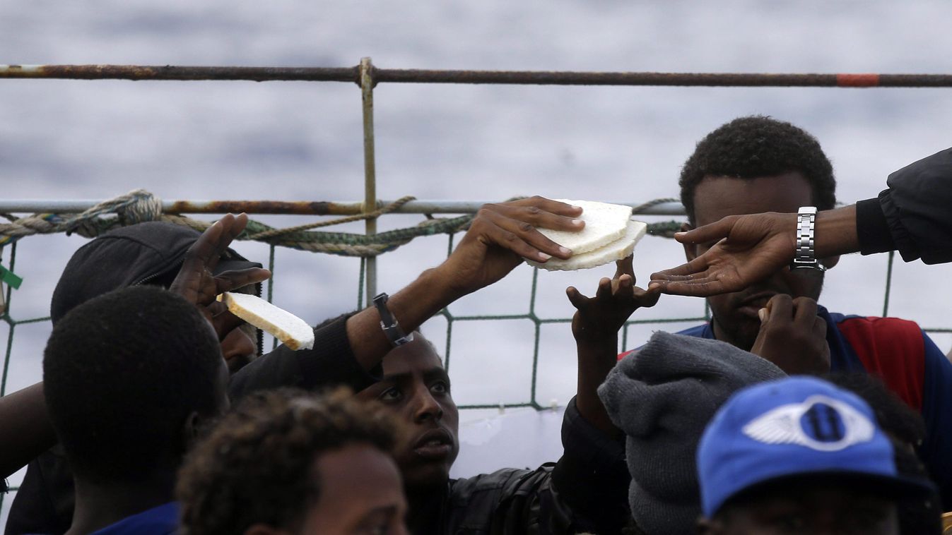 Földközi-tenger, 2015. június 24.
Menekültek kenyeret osztanak egymás között a belga haditengerészet Godetia nevű hajójának fedélzetén, miután kimentették őket a Földközi-tengerből, Líbia partjainál 2015. június 24-én. A Godetia ezen a napon több száz men