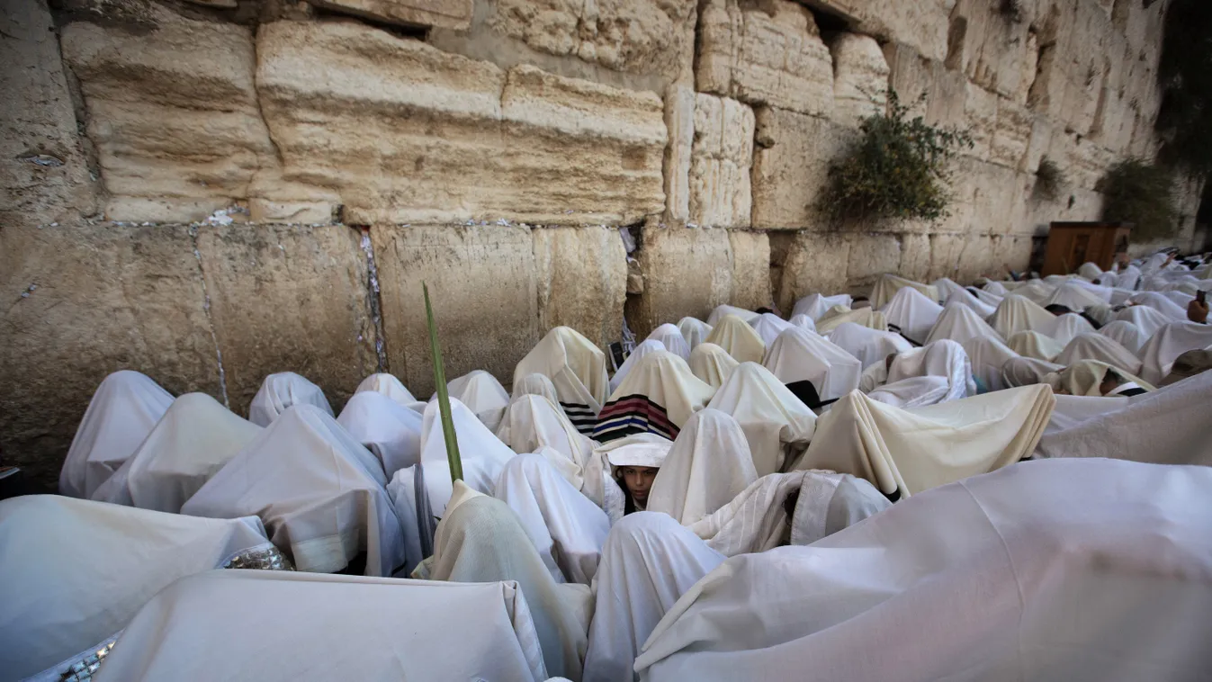 Jewish men draped in prayer shawls perform the annual Cohanim prayer (priest's blessing) during the Sukkot, or the feast of the Tabernacles, holiday at the Western Wall in the Old City of Jerusalem on October 12 2014. Tens of Thousands of Jews make the we