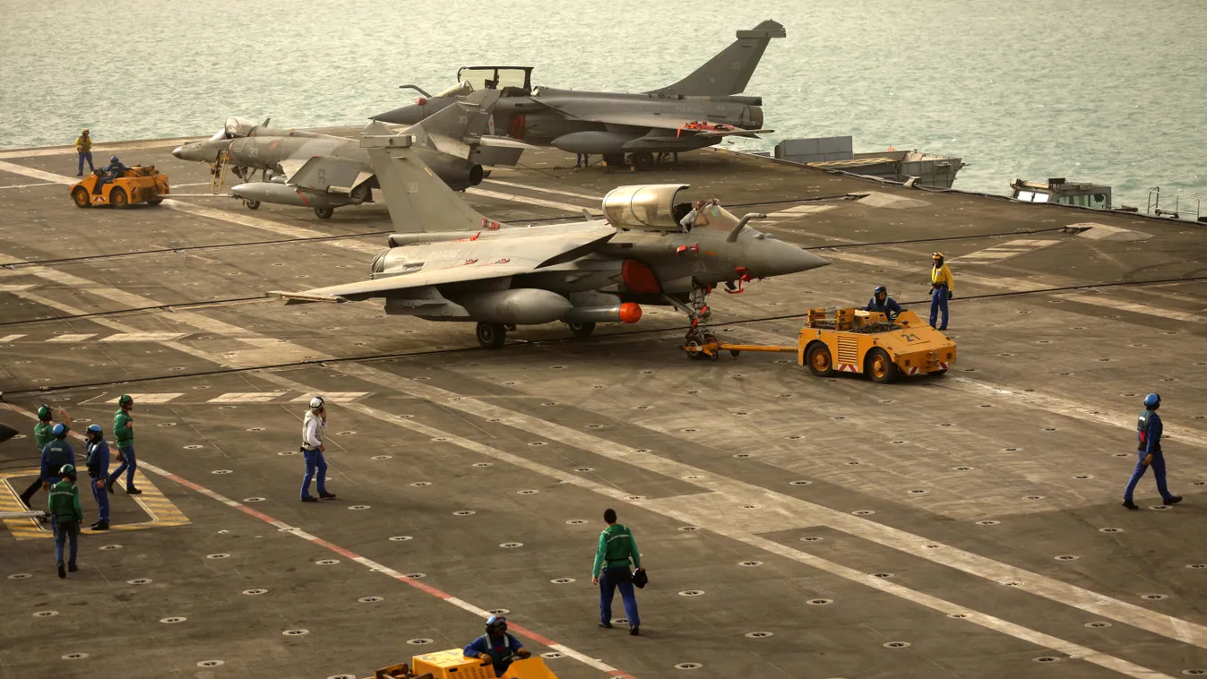 French Navy flight technicians pull a Rafale fighter jet on the deck of the aircraft carrier Charles de Gaulle sailing in the Gulf on February 22, 2015. AFP PHOTO / PATRICK BAZ 