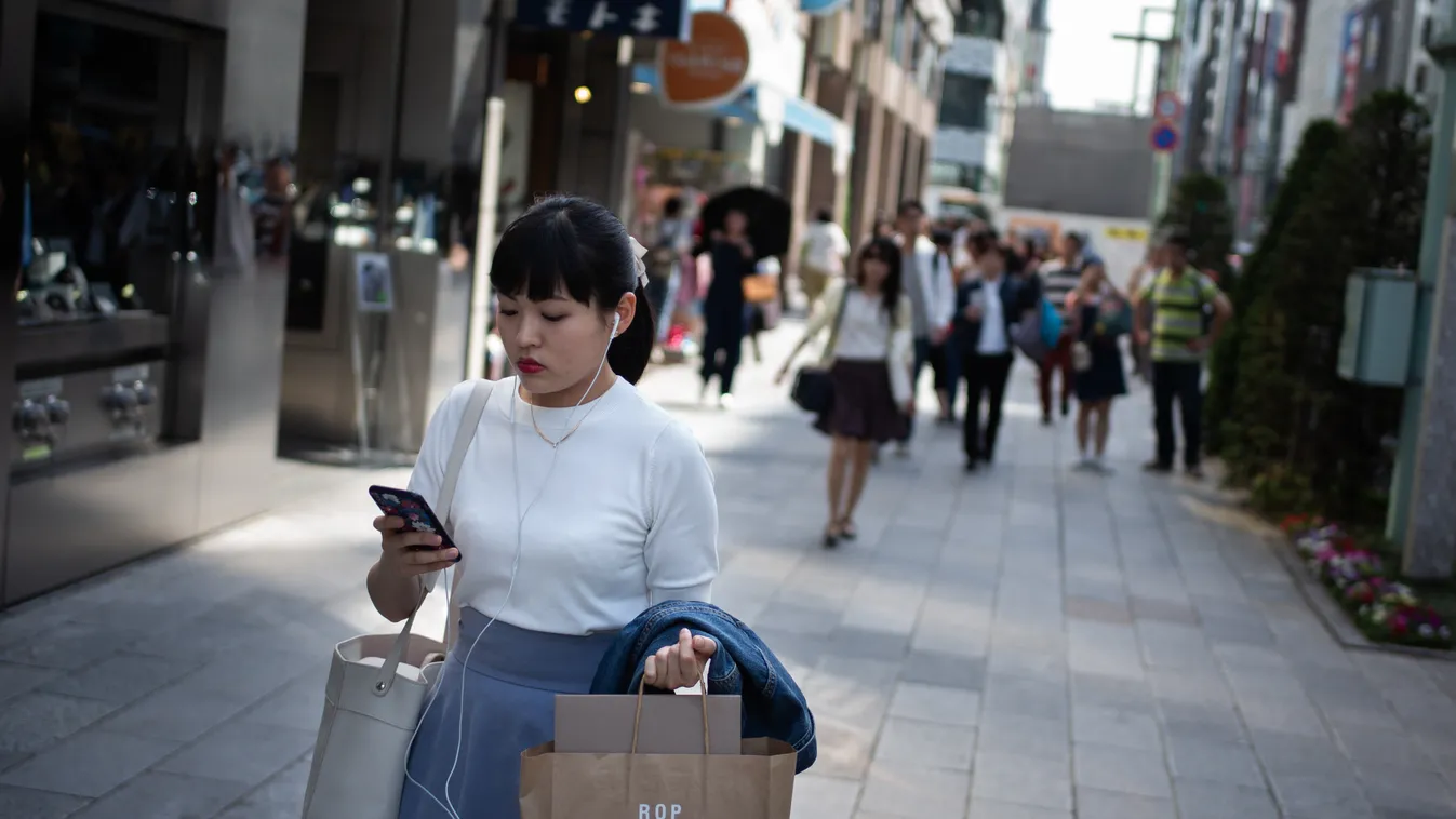 Horizontal DAILY LIFE WOMAN PASSER-BY SMARTPHONE CONCENTRATING STREET SCENE 