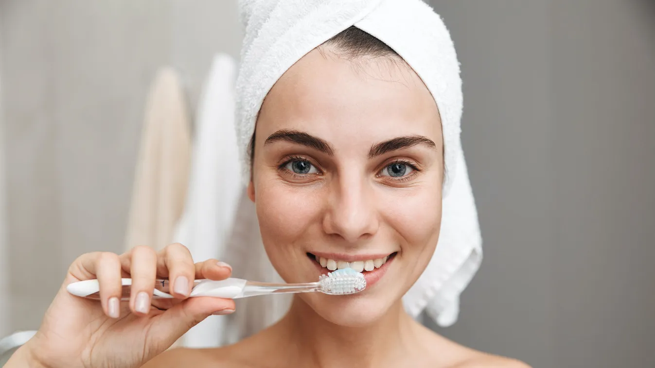 Close up of a beautiful young woman with towel beautiful bathroom towel hygiene dental morning woman beauty caucasian toothbrush brushing female attractive young pretty portrait lifestyle healthy happy teeth indoor adult care health oral smiling girl pers