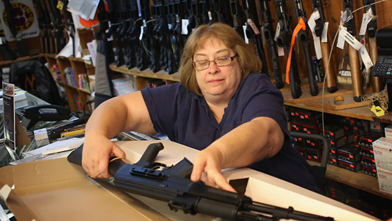 fegyver, fegyvertartás Amerikában, fegyverviselés, Cindy Sparr dobozba tesz egy AK-47- es típusú gépkarabélyt egy illionisi fegyverboltban 