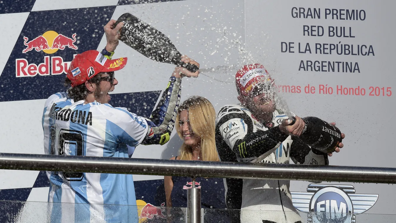 Italy's biker Valentino Rossi (L) of Yamaha sprays champagne over British Carl Crutchlow of Honda who came third, as he celebrates on the podium after winning the Argentina Grand Prix at Termas de Rio Hondo circuit, in Santiago del Estero, on April 19, 20