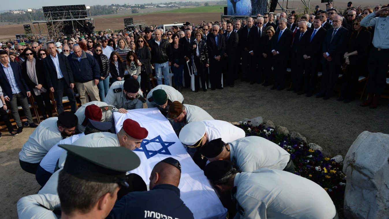 Ariel Saron volt izraeli miniszterelnök nemzetiszínű zászlóval letakart koporsóját helyezik a sírba a Saron család birtokán Havat Sikmimben 