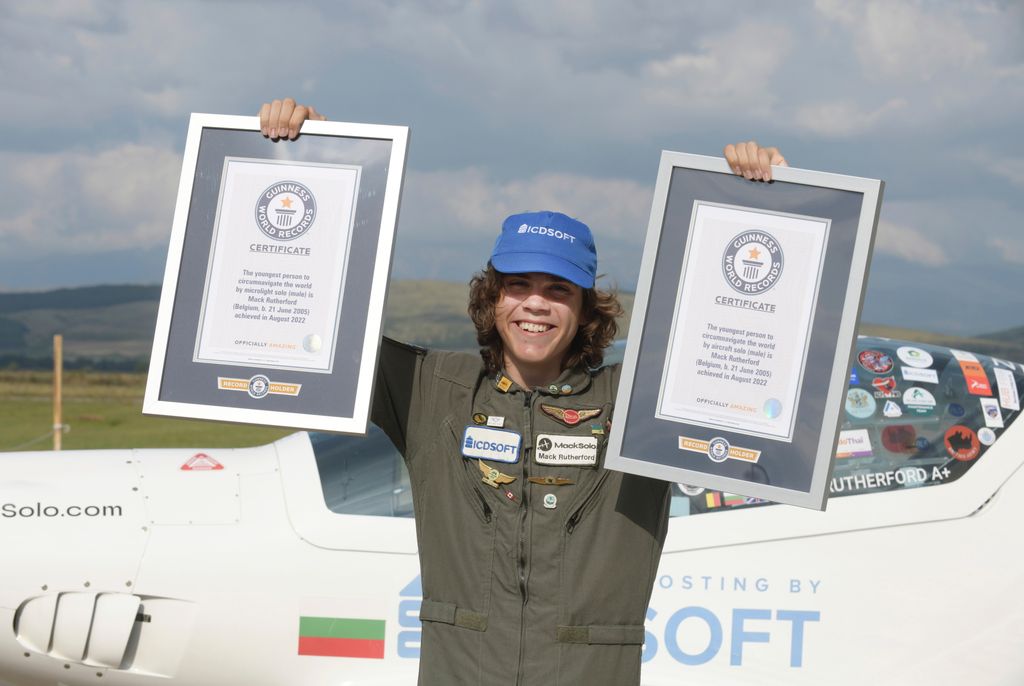 legfiatalabb pilóta, Föld, körberepülés,
Mack Rutherford 17 éves belga-brit pilóta fényképezkedik a két új világrekordját hitelesítő dokumentumokkal a Shark típusú ultrakönnyű légi járművével a háttérben a szófiai repülőtéren 2022. augusztus 24-én, a sike
