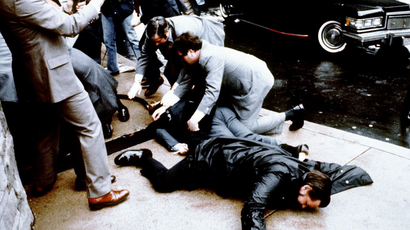 ASSASSINATION ATTEMPT CROWD PRESIDENT TERRORIST ATTACK MUGGING LYING DOWN HORIZONTAL POLICE BODYGUARD CASUALTY STREET This photo taken by presidential photographer Mike Evens on March 30, 1981 shows police and Secret Service agents reacting during the ass