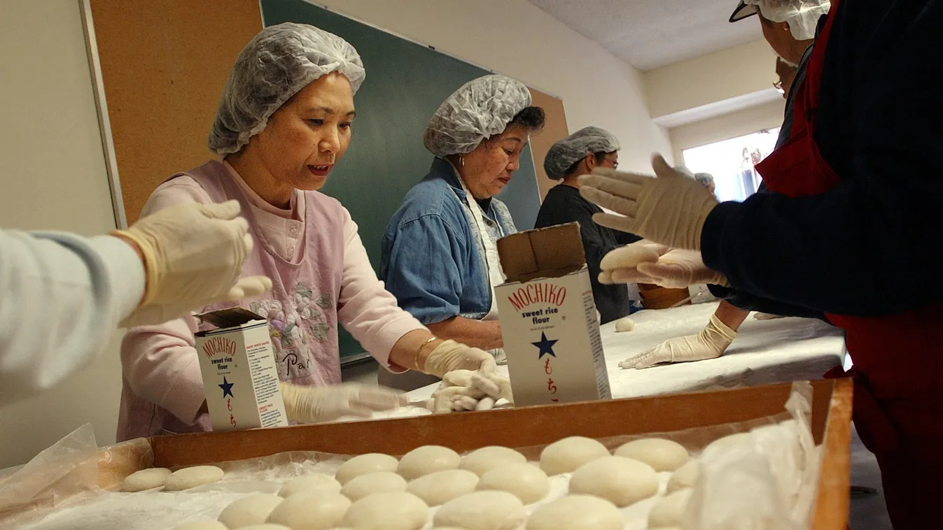 Etsuko Heatley (L), Angie Tsuneyoshi (C) and other women form cooked and pounded rice into small cakes as they participate in making Japanese rice cakes called mochi, 14 December, 2003, at the Buddhist Temple in San Diego, CA. The traditional method of ma
